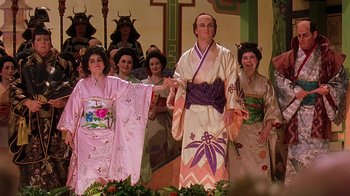 Movie still from “Topsy-Turvy” (1999), directed by Mike Leigh – A group of people dressed in traditional japanese clothing; Medium shot, Low angle