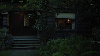 Movie still from “Touchy Feely” (2013), directed by Lynn Shelton – A lit candle in the window of a stone house at night; Extreme Wide shot, Low angle
