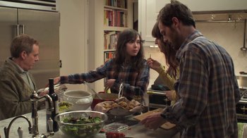 Movie still from “Touchy Feely” (2013), directed by Lynn Shelton – A group of people standing around a table with food on top of it; Medium shot, High angle