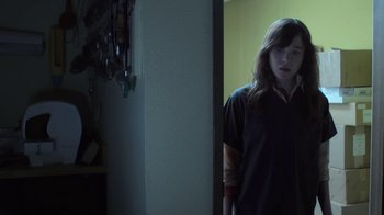 Movie still from “Touchy Feely” (2013), directed by Lynn Shelton – A woman standing in front of a mirror in a dark room; Medium shot, High angle