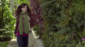 Movie still from “Touchy Feely” (2013), directed by Lynn Shelton – A woman walking down a sidewalk near a bush; Medium shot, Over the shoulder angle