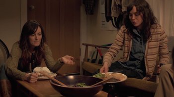 Movie still from “Touchy Feely” (2013), directed by Lynn Shelton – Two people sitting at a table with a bowl of food; Medium shot, Over the shoulder angle