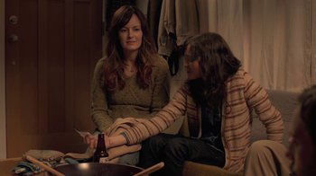 Movie still from “Touchy Feely” (2013), directed by Lynn Shelton – Two women sitting on a couch with a bottle of beer; Medium shot, Over the shoulder angle