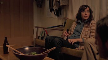 Movie still from “Touchy Feely” (2013), directed by Lynn Shelton – A woman sitting on a chair holding a bottle of wine; Medium shot, High angle