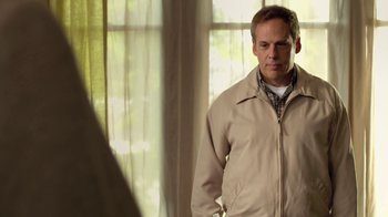 Movie still from “Touchy Feely” (2013), directed by Lynn Shelton – A man standing in front of a mirror in a room; Medium shot, Over the shoulder angle