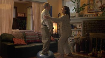 Movie still from “Touchy Feely” (2013), directed by Lynn Shelton – An older man standing on an exercise ball with an older woman in a living room; Wide shot, Low angle