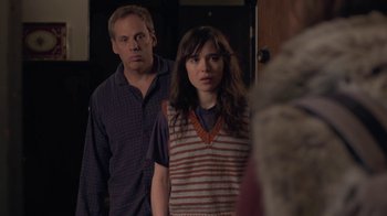 Movie still from “Touchy Feely” (2013), directed by Lynn Shelton – A man and a woman standing next to each other in a room; Medium shot, Over the shoulder angle