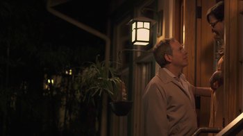 Movie still from “Touchy Feely” (2013), directed by Lynn Shelton – A man standing in front of a building at night; Medium shot, Low angle