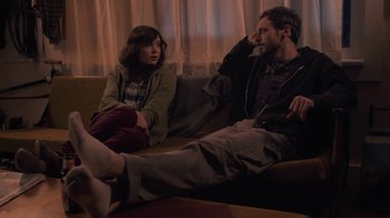 Movie still from “Touchy Feely” (2013), directed by Lynn Shelton – A man and a woman sitting on a couch listening to music; Medium shot, High angle