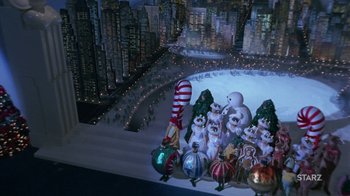 Movie still from “Toys” (1992), directed by Barry Levinson – A group of christmas decorations on display in front of a city skyline at night; Extreme Wide shot, High angle