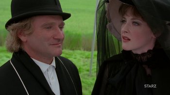 Movie still from “Toys” (1992), directed by Barry Levinson – A man and a woman in a black suit and hat; Close Up shot, Over the shoulder angle