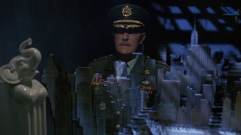 Movie still from “Toys” (1992), directed by Barry Levinson – A man in a military uniform is reflected in a mirror; Wide shot, Over the shoulder angle