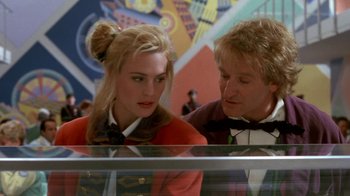 Movie still from “Toys” (1992), directed by Barry Levinson – A man and a woman looking at each other in front of a display case; Close Up shot, Over the shoulder angle