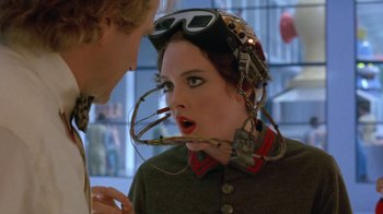 Movie still from “Toys” (1992), directed by Barry Levinson – A woman wearing goggles and a helmet talking to a man; Close Up shot, Over the shoulder angle