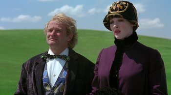 Movie still from “Toys” (1992), directed by Barry Levinson – A man and a woman standing next to each other; Medium shot, Low angle