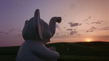 Movie still from “Toys” (1992), directed by Barry Levinson – An elephant statue in the middle of a field at sunset; Extreme Wide shot, Low angle