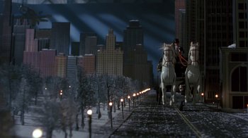Movie still from “Toys” (1992), directed by Barry Levinson – A couple of horses pulling a carriage down a street; Extreme Wide shot, High angle