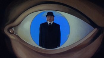 Movie still from “Toys” (1992), directed by Barry Levinson – A man in a suit and hat is seen through an image of an eye; Extreme Close Up shot, Low angle