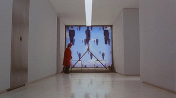 Movie still from “Toys” (1992), directed by Barry Levinson – A man in a red jacket standing in front of a screen; Wide shot, High angle