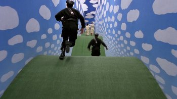 Movie still from “Toys” (1992), directed by Barry Levinson – Two people are walking down a stair way; Extreme Wide shot, High angle