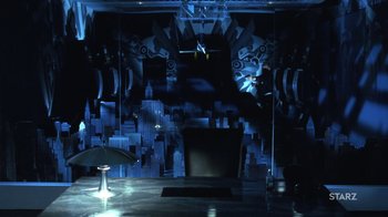 Movie still from “Toys” (1992), directed by Barry Levinson – A dark room with a black chair and umbrella; Extreme Wide shot, Low angle