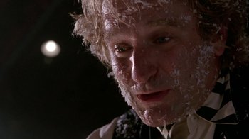 Movie still from “Toys” (1992), directed by Barry Levinson – A person wearing a suit and tie; Close Up shot, Low angle