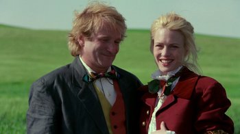 Movie still from “Toys” (1992), directed by Barry Levinson – A man and a woman standing next to each other; Medium shot, Low angle