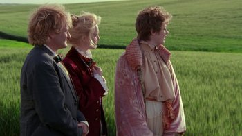Movie still from “Toys” (1992), directed by Barry Levinson – A group of people standing next to each other in front of a field; Medium shot, Over the shoulder angle