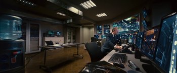 Movie still from “Trance” (2013), directed by Danny Boyle – A man sitting at a computer desk; Wide shot, High angle