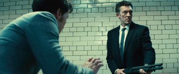 Movie still from “Trance” (2013), directed by Danny Boyle – Two men in business suits talking to each other; Medium shot, Low angle