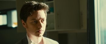 Movie still from “Trance” (2013), directed by Danny Boyle – A man with a white shirt is looking into the distance; Close Up shot, Over the shoulder angle