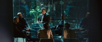 Movie still from “Trance” (2013), directed by Danny Boyle – A group of people sitting in a room; Wide shot, Over the shoulder angle