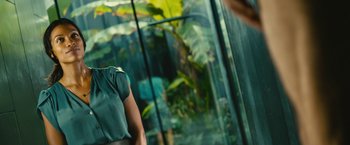 A woman holding an umbrella in front of a glass wall