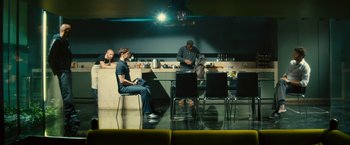 Movie still from “Trance” (2013), directed by Danny Boyle – A group of people sitting at a table in a room; Wide shot, High angle