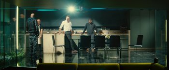 Movie still from “Trance” (2013), directed by Danny Boyle – Two men standing in front of a table in front of a bar; Wide shot, Low angle