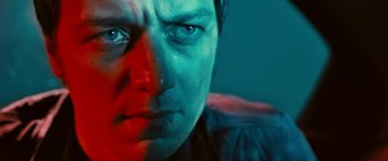 Movie still from “Trance” (2013), directed by Danny Boyle – A man's face in a blue and red light; Close Up shot, Low angle