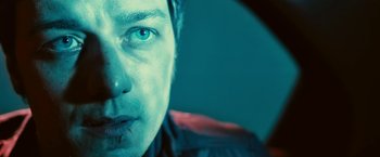 Movie still from “Trance” (2013), directed by Danny Boyle – A man's face in a dark room; Close Up shot, Low angle