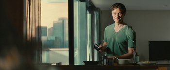 Movie still from “Trance” (2013), directed by Danny Boyle – A man holding a remote control in front of a mirror; Medium shot, Over the shoulder angle