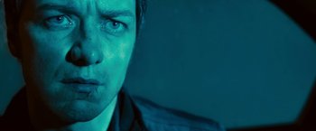 Movie still from “Trance” (2013), directed by Danny Boyle – A man's face in the dark; Close Up shot, Low angle