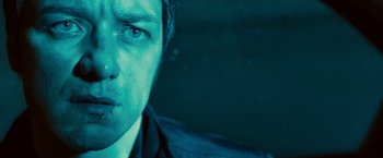 Movie still from “Trance” (2013), directed by Danny Boyle – A man's face in the dark; Close Up shot, Low angle