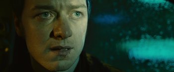 Movie still from “Trance” (2013), directed by Danny Boyle – A man's face in a dark room; Close Up shot, Over the shoulder angle