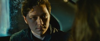 Movie still from “Trance” (2013), directed by Danny Boyle – A person in a car looking at the camera; Close Up shot, Over the shoulder angle