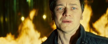 Movie still from “Trance” (2013), directed by Danny Boyle – A man's face in front of a fire pit; Close Up shot, Low angle