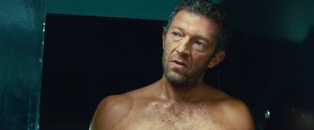 Movie still from “Trance” (2013), directed by Danny Boyle – A man with a beard is looking into the mirror; Close Up shot, Over the shoulder angle