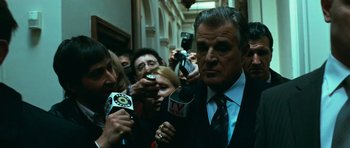 Movie still from “Transporter 3” (2008), directed by Olivier Megaton – A group of people standing next to each other holding microphones; Medium shot, Low angle
