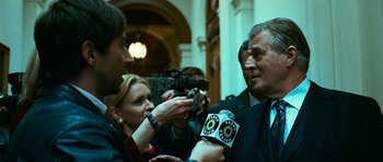 Movie still from “Transporter 3” (2008), directed by Olivier Megaton – A group of people standing next to each other on the floor; Medium shot, Over the shoulder angle