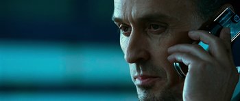 Movie still from “Transporter 3” (2008), directed by Olivier Megaton – A man's face with his hand resting on his ear; Close Up shot, Low angle