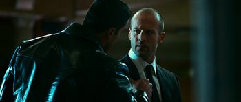 Movie still from “Transporter 3” (2008), directed by Olivier Megaton – A man in a suit and a man in a leather jacket; Close Up shot, Over the shoulder angle