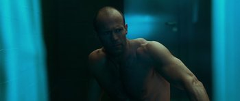 Movie still from “Transporter 3” (2008), directed by Olivier Megaton – A man with no shirt is standing in a bathroom; Close Up shot, Low angle