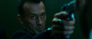 Movie still from “Transporter 3” (2008), directed by Olivier Megaton – A person holding a gun; Close Up shot, Low angle